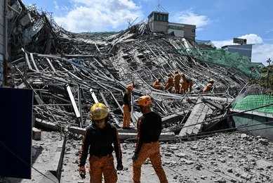shutterstock_2794925219 Rescue workers survey collapsed building debris