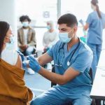 Identity Theft Fueled COVID Test Grift Healthcare worker vaccinating woman in clinic setting