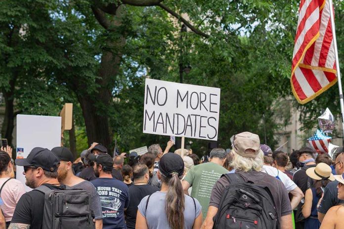 202226174 Crowd holds No More Mandates sign at protest.