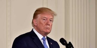 Capital One Drops Trump — Why Now? man in suit at a podium