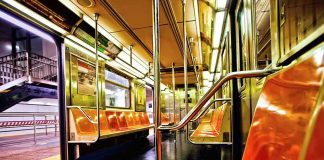 Empty subway car with orange seats and open doors