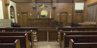 Officer Lied Under Oath — Case Implodes Interior view of an empty courtroom with wooden benches and a judges bench