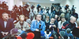 Row of microphones on a table at a press conference