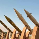 Row of surface-to-surface missiles mounted on display stands outdoors
