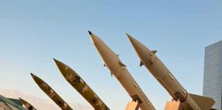 Missiles, Militias—Non‑Negotiable Row of surface-to-surface missiles mounted on display stands outdoors