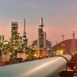 Oil refinery with pipelines at sunset