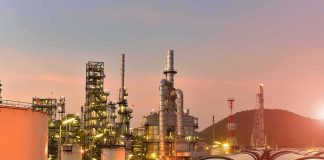 Oil refinery with pipelines at sunset