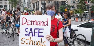 School Retaliation? Mom Hits Federal Court Protester holding a sign at a city street demonstration