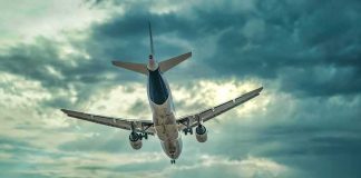 Commercial airplane approaching for landing under dramatic cloudy sky
