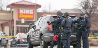 Shoplifting Jump Turns Into Highway Horror Police officers gather beside a patrol SUV at a taped-off scene