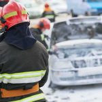 Official Story Keeps Shifting—Why? Firefighter near foam-covered car with open hood