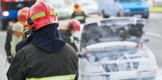 Official Story Keeps Shifting—Why? Firefighter near foam-covered car with open hood