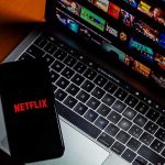 Smartphone with Netflix logo on a laptop keyboard
