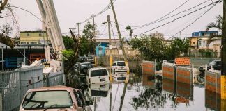 Dozens Pulled From Submerged Streets Flooded urban street with abandoned cars and downed power lines