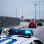 Police car with blue lights on near a roadway
