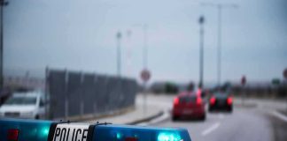 FBI Bombshell: Wild Alias Buying Spree Police car with blue lights on near a roadway