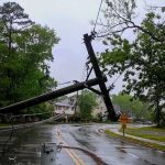 Powerless Aftershock: California Left Guessing Fallen utility poles blocking a wet suburban street