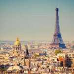 A panoramic view of Paris featuring the Eiffel Tower and a golden dome