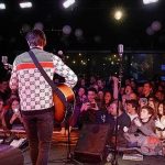 Rock Star Raises Flag, Dares Fans: Pick Sides Guitarist performing on stage facing a cheering crowd