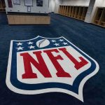 NFL Star Dies Suddenly at 36 NFL logo on the floor of an empty locker room