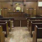U.S. Arrests Andrew and Tristan Tate Interior view of an empty courtroom with wooden benches and a judges bench