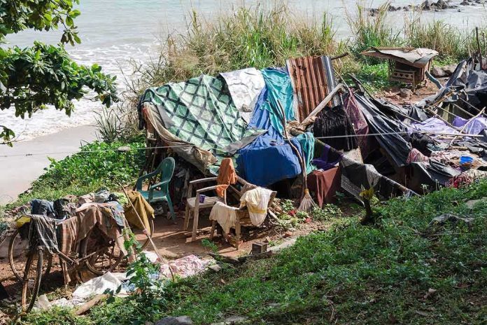 shutterstock_1227905014 makeshift shelter near a beach with tarps and clothes drying