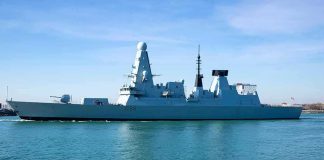 naval destroyer sailing in calm harbor waters