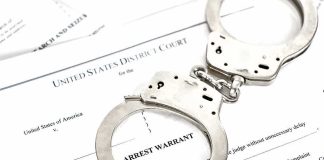 Handcuffs on arrest warrant documents