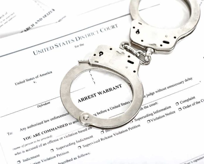 Handcuffs on arrest warrant documents
