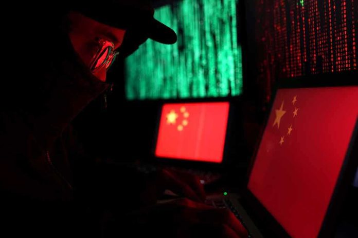shutterstock_1339292231 Hooded person using a laptop with Chinese flags on screens