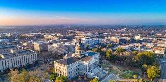 State capitol building with dome in a cityscape at sunrise