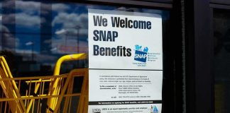 Store window with SNAP benefits signs and yellow shopping carts