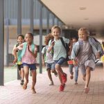 Group of schoolchildren running down a hallway