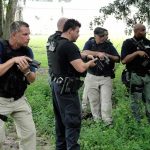 law enforcement officers conducting a search in a wooded area