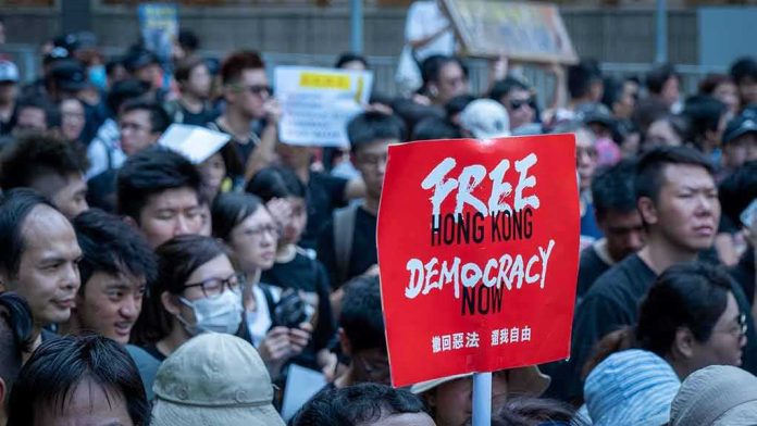 Protesters gathered with a red sign held aloft