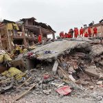 Hydropower Chaos — Workers Vanish Underground Rescue workers in orange uniforms on a collapsed building site after an earthquake