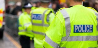 Police officers in high-visibility jackets standing on a street