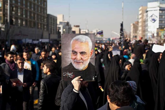 Qasem Soleimani portrait held aloft in a crowded street gathering