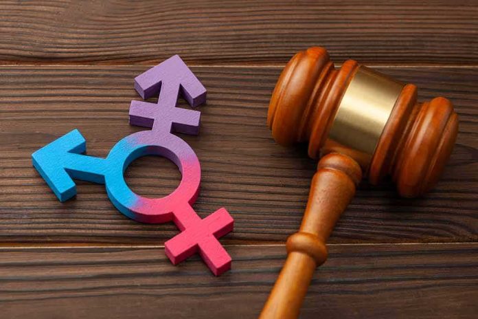 Wooden gavel beside multicolored transgender symbol