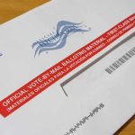 Appeals Court Greenlights Controversial USPS Shift Mail-in ballot envelope with red label on wooden table