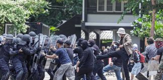 Protesters clash with riot police holding shields