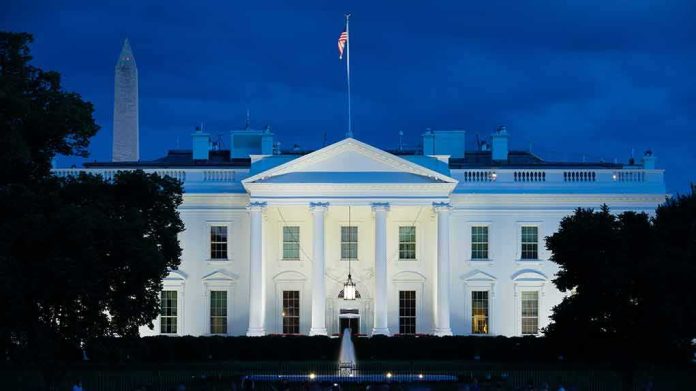 White House illuminated at dusk with flagpole and columns