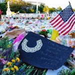 A Celebrity Post Fuels a 9/11 Controversy Memorial site with flowers and a U.S. flag