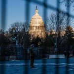 U.S. Capitol behind security fencing and guards on a street