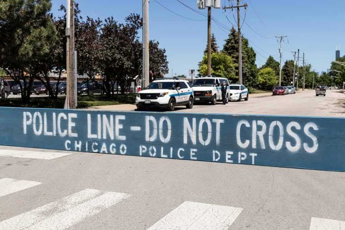 Police line barrier blocking a street with patrol vehicles behind