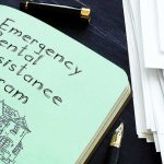 Photo ID? ABC Host Calls Out Warner Notebook titled Emergency Rental Assistance Program beside papers and pen
