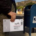 Ballot Tracking System Suddenly Frozen Person mailing a ballot envelope at a blue USPS street mailbox