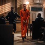 Double Murder — Suicide Gown Stuns Court Defendant in orange jumpsuit escorted by officer in courtroom