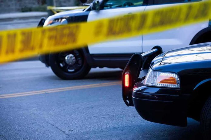 Police cars behind yellow caution tape at a street scene
