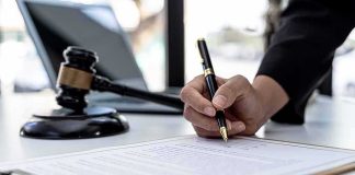 60 Minutes Showdown: Grief Vs. Conspiracies Hand signing legal document beside gavel and laptop
